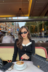 a lady wears a black knitted top with a square neckline design